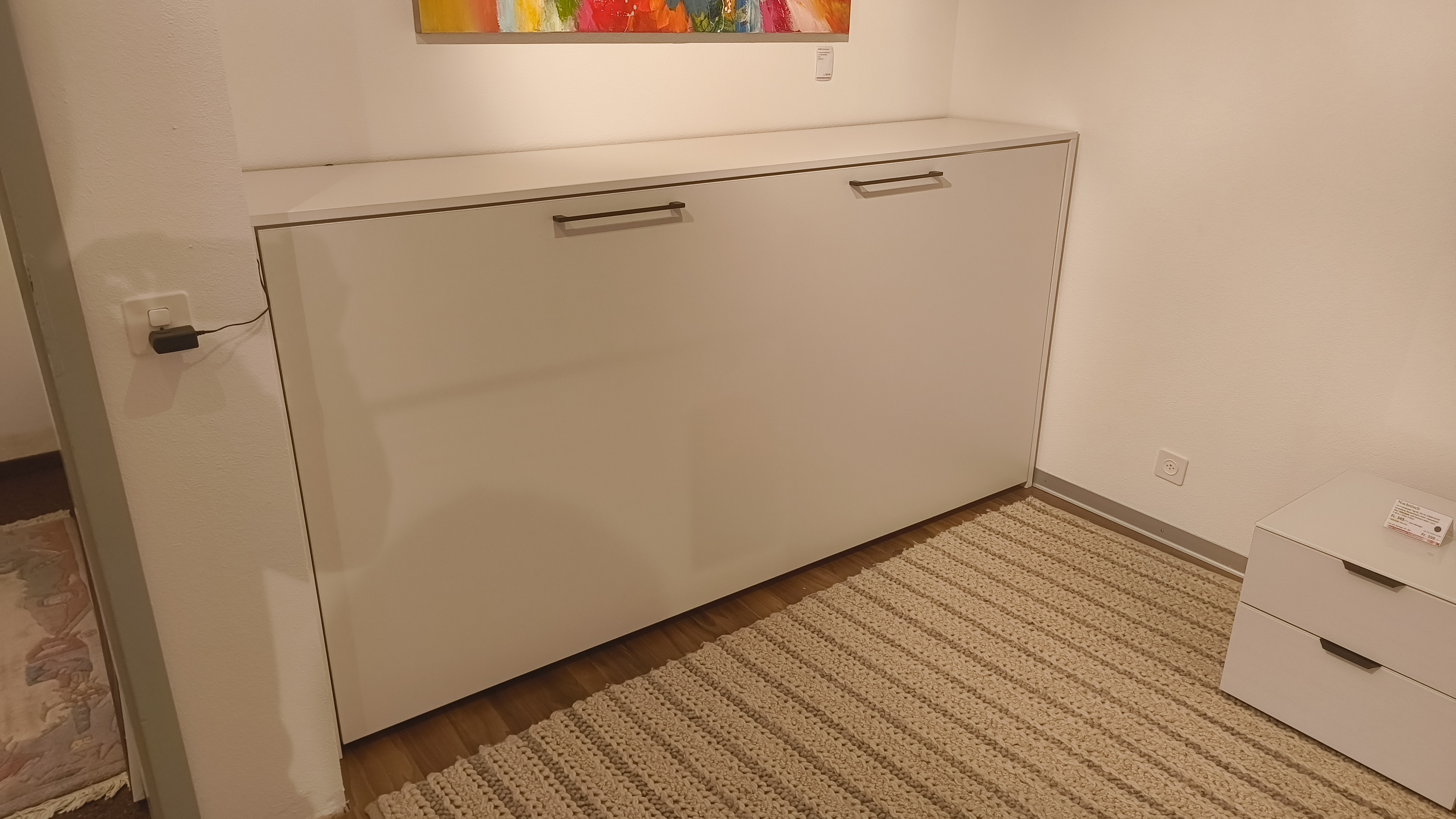 low cabnit, weißer schrank, zwei grub griffe, elektrische steckdose, netzstecker